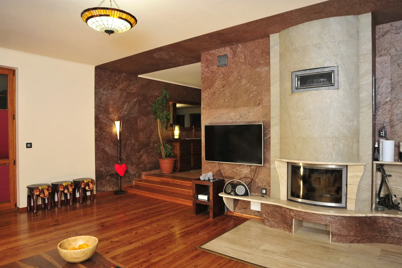 Warm living room finished with natural stone wall veneer around a fireplace