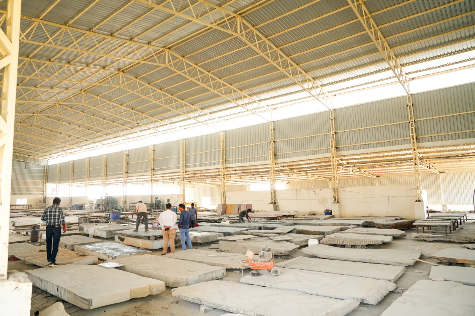 Wide interior view of a stone processing facility with large stone pieces