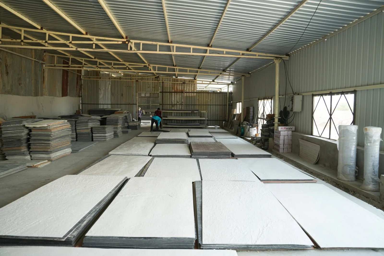 Stone slabs and finished material arranged inside a covered warehouse