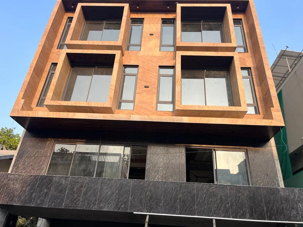 Modern building facade using dark and warm stone finishes